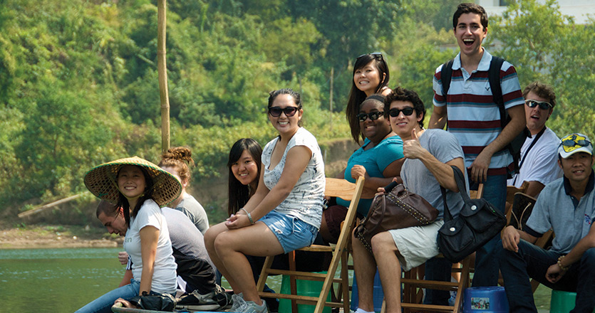 International students sitting on a boat in Shanghai on a river