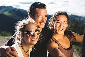 Seaver College students smiling at the top of a mountain